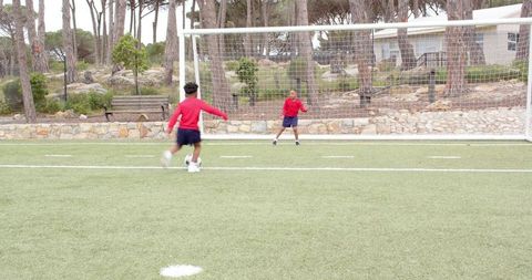 Youth Soccer Players Kicking Ball on Turf Field