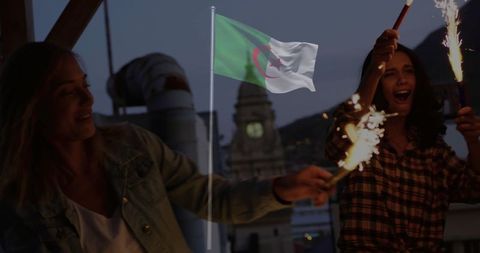 Women Celebrating with Sparklers Under Algerian Flag