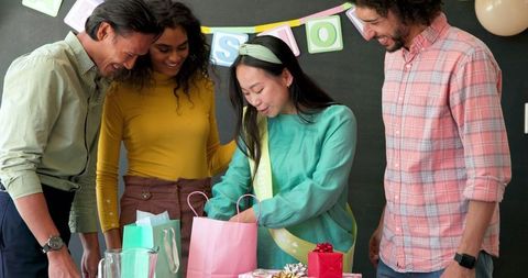 Multiracial colleagues celebrate office baby shower with gifts
