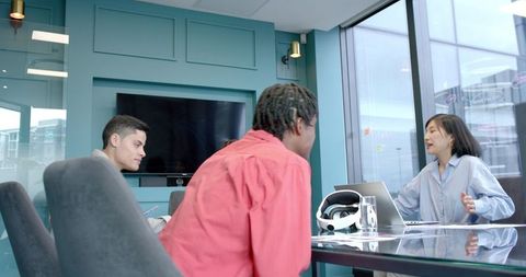 Diverse Team Collaboration with Laptop and VR Technology in Modern Office