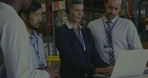 Warehouse Team Collaborating with Laptop and Inventory for Effective Management