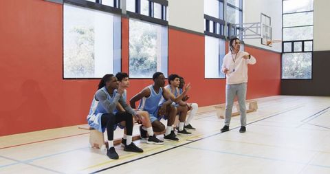 Young Basketball Team Engaged in Coaching Session in Gym