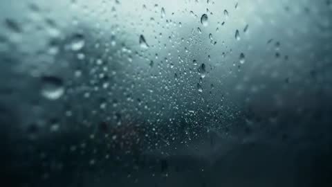 Raindrops Creating Patterns on Glass Window by Merging in Stream Flow