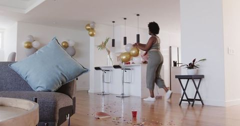 Woman Cleaning Messy Living Room After Party Celebration