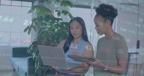Diverse Businesswomen Analyzing Financial Data on Laptop in Office