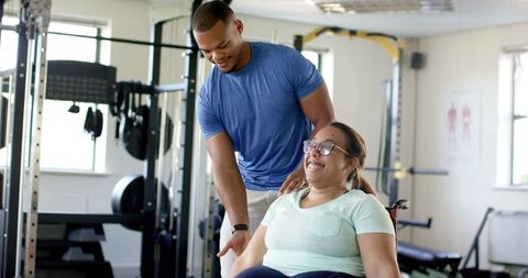 Personal trainer assisting woman in rehabilitation therapy