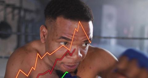 Shirtless male boxer training and punching in ring with performance charts overlay