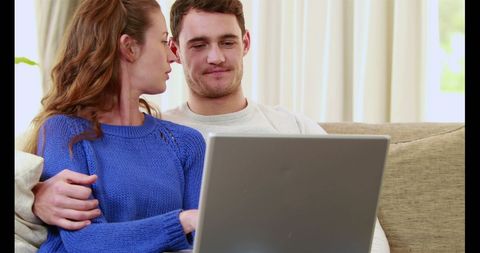 Young Couple Relaxing on Couch Surfing Laptop Together