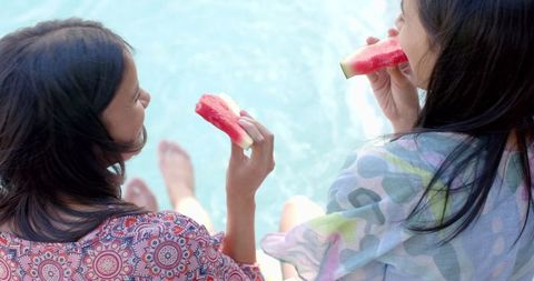 Teen Girls Relax by Pool Enjoying Watermelon in Summer Sun
