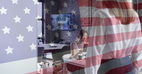 Double Exposure of Businesswoman and American Flag in Modern Office