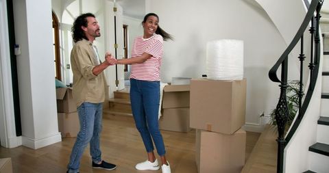 Couple Moving Into New Home Smiling and Celebrating