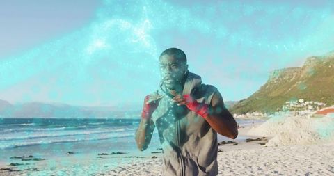 Shadowboxing athlete on seaside beach with red hand wraps and turquoise glow