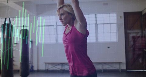 Woman executing overhead stretch amid fitness trend graphics