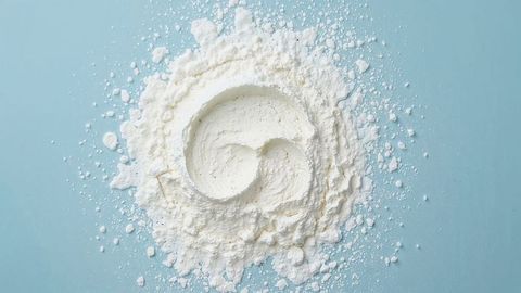 Spiral milk powder arrangement on pastel blue canvas