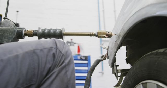 Mechanic Using Pneumatic Hammer to Repair Car - Download Free Stock Images Pikwizard.com