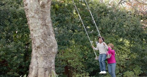 Mother Pushing Son on Tree Swing Outdoor Playtime Fun - Download Free Stock Images Pikwizard.com
