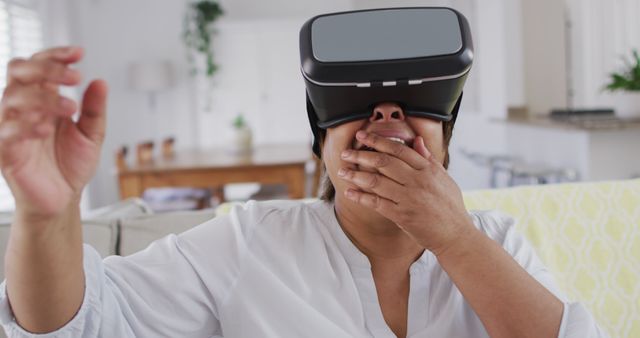 Surprised Woman Using Virtual Reality Headset in Living Room - Download Free Stock Images Pikwizard.com