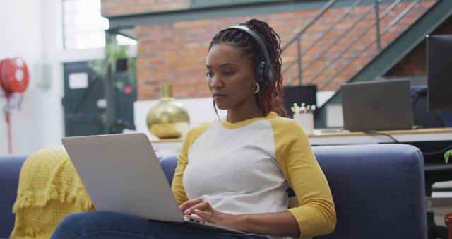 Young Woman Wearing Headphones and Using Laptop at Modern Office - Download Free Stock Images Pikwizard.com