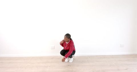 Woman in red hoodie contemplating on wooden floor