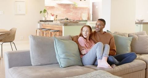 Young couple relaxing on stylish sofa in modern home interior