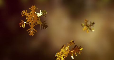 Golden snowflakes falling on brown background