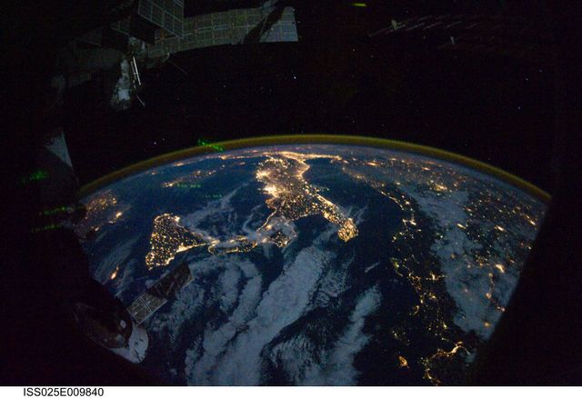 Photograph showcases a mesmerizing night view of parts of Europe and Africa from the International Space Station. Italy and Sicily, along with the Mediterranean Sea, are prominent. City lights illuminate visible regions. Perfect for educational use in geography and astronomy subjects, space exploration articles, and environmental studies.