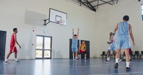 Athletes Competing in Indoor Basketball Game on Polished Court
