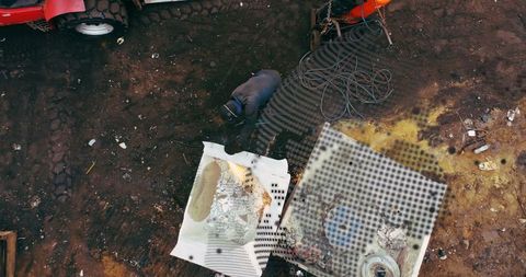 Aerial View of Worker in Junkyard with Overlaid Globe Projection