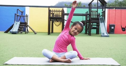 Joyful Girl Exercising on Playground Mat