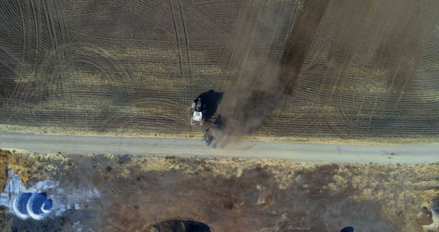 Aerial view of a tractor plowing a field, with copy space. Captured outdoors, the image showcases agricultural machinery at work in a rural landscape.