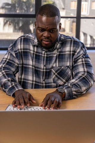 Man working on laptop with focus and determination at office desk