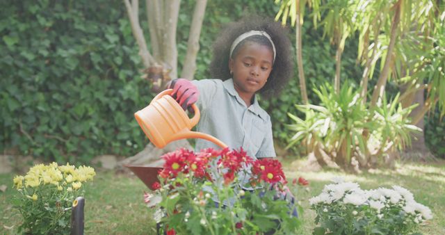 Happy african american girl watering flowers in garden - Download Free Stock Photos Pikwizard.com