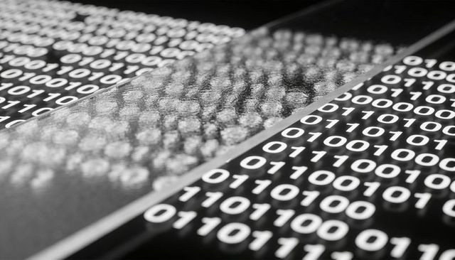 Glossy panels displaying binary code reflecting light across tabletop representing digital data