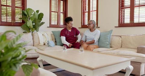 Nurse providing care for senior at home, expressing warmth and support