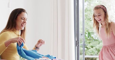 Mother and Daughter Packing Clothes Together for a Vacation Trip