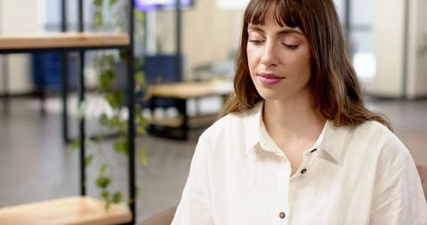 Woman Relaxing in Contemporary Office Lounge with Greenery