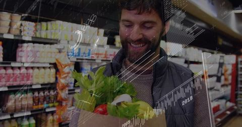 Bearded shopper smiling while checking fresh greens and red pepper in grocery store
