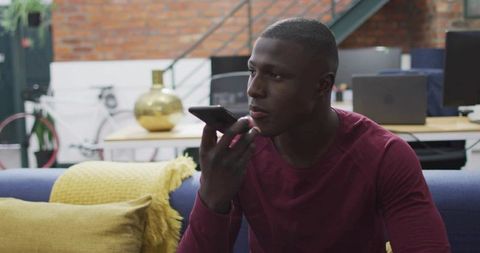 Man Recording Voice Message on Smartphone in Modern Loft Lounge Casual Workspace