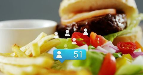 Closeup burger and fries with fresh salad and social media follower notification bubble