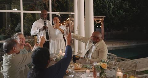 Senior Friends Toasting at Joyful Backyard Wedding Celebration