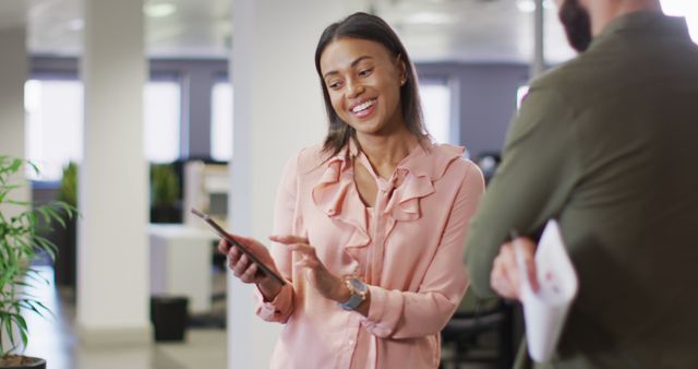 Smiling Businesswoman Collaborating with Colleague at Modern Office - Download Free Stock Images Pikwizard.com