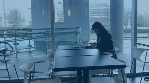 Caucasian Woman Working on Laptop in Modern Cafe