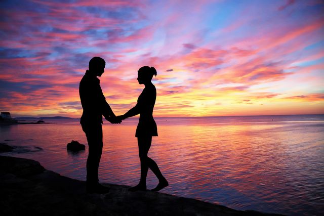 Capturing a romantic moment at sunset by the ocean can be perfect for relationships, travel, and vacation themes. This setting can be used in ads or websites suggesting togetherness or serenity.