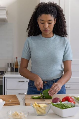 Woman preparing fresh vegetables in modern home kitchen
