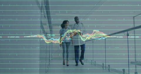 Business professionals walking with tablet and analytics overlay in modern corridor
