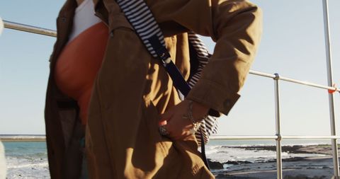 Woman fashionably walking by seaside with ocean background