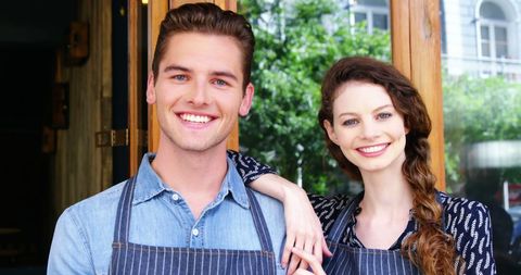 Happy Couple Welcoming Customers to Cozy Café