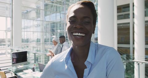 Confident Businesswoman Smiling in Sunlit Modern Office