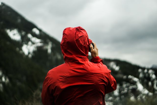 Person in Red Hoodie Taking a Photo in Front of Mountain - Download Free Stock Photos Pikwizard.com