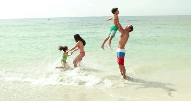 Family playing in water at the beach